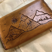Picture of a leather wallet with a mountain sketch